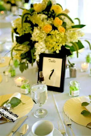 A table set with plates and glasses, candles and flowers.